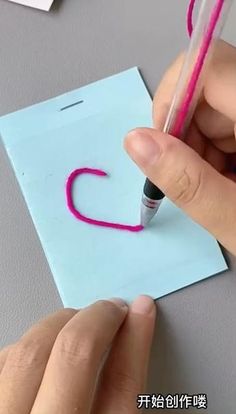 someone is writing the letter c on a piece of paper with a crayon pen