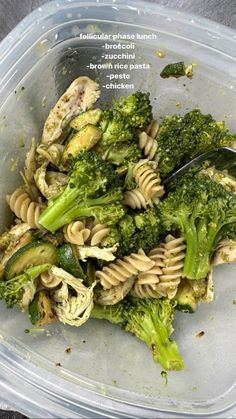 a plastic container filled with pasta and broccoli