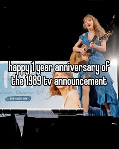 a woman in blue dress holding a guitar on stage with the caption happy 1 year anniversary of the 1989 tv announcement