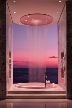 a large bath tub sitting in the middle of a bathroom next to an ocean view