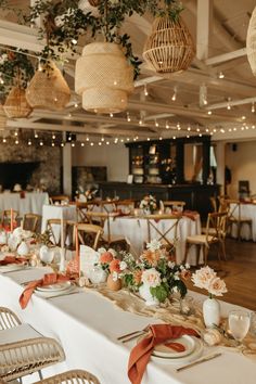 tables set up for an event with white linens and orange ribbons