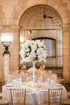 a table set up with white flowers and candles for a wedding reception at the grand america hotel