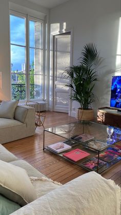 a living room filled with furniture and a flat screen tv sitting on top of a wooden floor