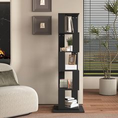 a living room with a white chair and black bookcase in front of a fireplace