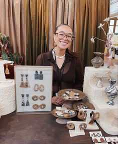 a woman sitting at a table with some desserts and other items on the table