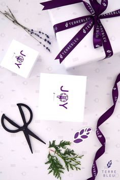 purple ribbon and scissors are laying on the table