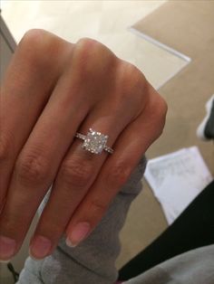 a woman's hand with a diamond ring on it