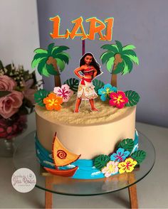 a cake decorated with an image of a woman on the beach and palm trees is shown