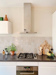 a stove top oven sitting inside of a kitchen next to a wall mounted range hood