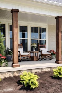 a porch with rocking chairs and potted plants on the front steps next to it