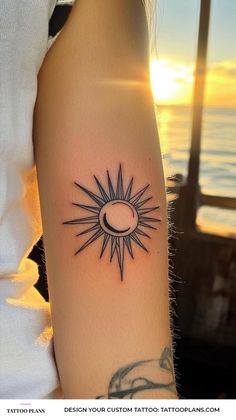 a woman's arm with a sun and moon tattoo on it