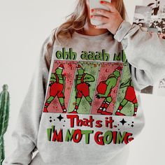 a woman taking a selfie in front of a cactus wearing an ugly sweatshirt that says, oh again i'm that is it i'm not going