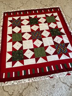 a red and white quilt on the floor