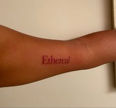 a person's arm with the word eubreal tattooed on it, in red ink