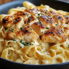 pasta with chicken and parmesan cheese in a black bowl