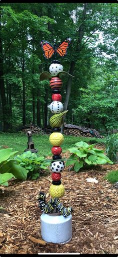 a sculpture made out of balls and yarn with a butterfly sitting on top of it