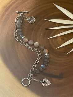 This bracelet is made of labradorite and peach moonstones. There are a few rhinestones in the design, as well as silver plated components. This bracelet has a chain for a double layered look. There natured inspired charms includes sunflower and a leaf. This bracelet fits a 6.5” wrist (8 inches long). If you prefer to have the bracelet larger than 6.5”, I can accommodate your request. Message me when you place the order. Bohemian Silver Crystal Bracelet With Gemstone Beads, Silver Beaded Bracelets With Natural Stones And Dangle, Silver Beaded Bracelet With Natural Stones And Dangle, Bohemian Silver Moonstone Crystal Bracelet, Silver Double Strand Beaded Bracelets With Gemstones, Silver Double Strand Bracelet With Natural Stones, Silver Labradorite Bracelets With Gemstone Beads, Silver Labradorite Bracelet With Gemstone Beads, Silver Labradorite Gemstone Bead Bracelets