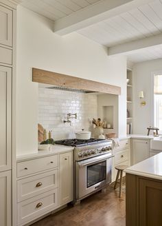 a kitchen with an oven, stove and counter tops in white painted wood paneling