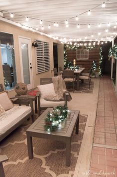 an outdoor living room with christmas lights on the ceiling