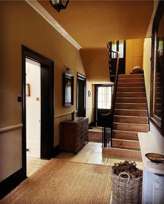 an entry way with stairs and baskets on the floor