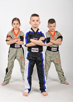 two boys and a girl are standing in front of a white background with their arms crossed