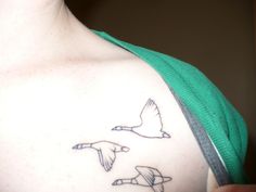 a person with a tattoo on their chest and two birds flying over them, one bird is in the foreground