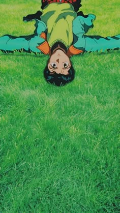 a person laying on the ground in grass