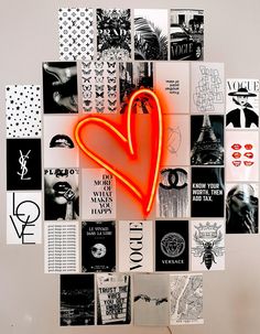 a heart shaped neon sign surrounded by many different types of posters