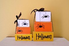 two halloween decorations made to look like blocks with spider faces on them, sitting on a table