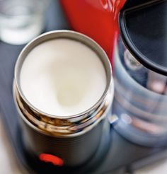 a close up of a cup on a table with other items in the back ground