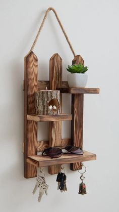 a wooden shelf that has some keys hanging from it and a potted plant on top