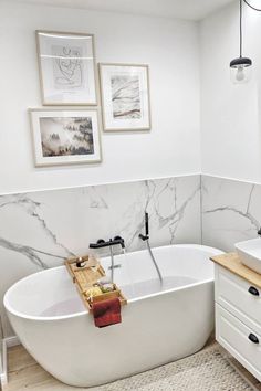 a white bath tub sitting next to a sink in a bathroom on top of a rug