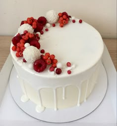 a white cake with red and white toppings on a platter, ready to be eaten