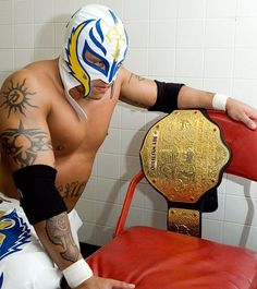 a man in a wrestling ring with his arm wrapped around the edge of a chair