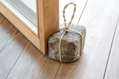 a rock wrapped in twine is sitting on the floor next to an open door