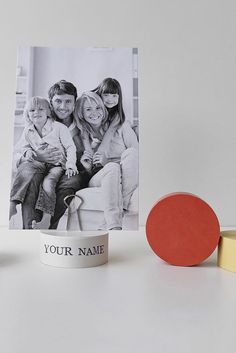 an image of a family sitting on a couch next to a photo and two candles