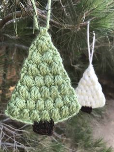 two crocheted ornaments hanging from a pine tree