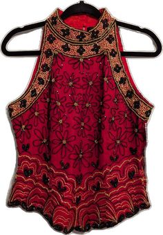 Glamorous Red Sleeveless Top, Festive Sleeveless Holiday Top, Festive Beaded Sleeveless Top, Festive Sleeveless Beaded Top, Red Embellished Sleeveless Top, Red Halter Neck Top For Evening, Red Embroidered Tops For Party, Festive Embellished Sleeveless Top, Red Embellished Fitted Tops