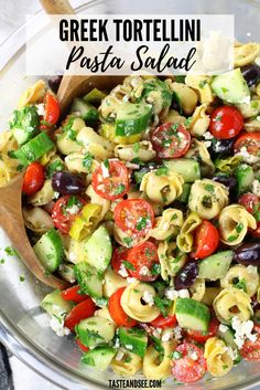 a bowl full of pasta salad with olives, tomatoes and cucumbers in it