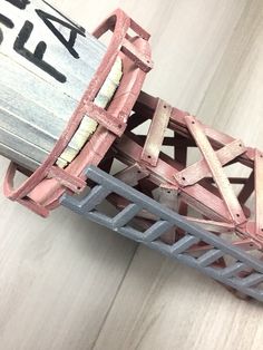 a close up of a toy train on a wooden floor with graffiti written on it