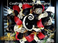 a red and black mesh wreath with leopard print, ribbon and bow on the front door