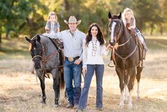 a man, woman and two children are standing next to a horse