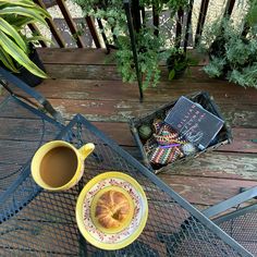 a cup of coffee and some croissants sitting on a table with books