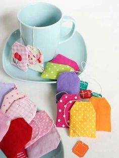 several pieces of fabric sitting on a plate next to a cup and saucer