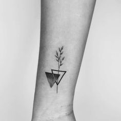 a black and white photo of a plant tattoo on the left side of the ankle