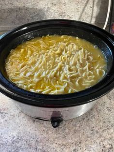 a crock pot filled with macaroni and cheese sitting on a counter top