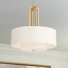 a light fixture hanging from the ceiling in a room with a painting on the wall