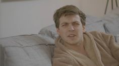 a man wrapped in a towel sitting on top of a bed