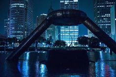 the city skyline is lit up at night with skyscrapers in the backgroud