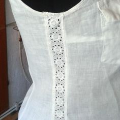 a woman's white blouse with black trimmings